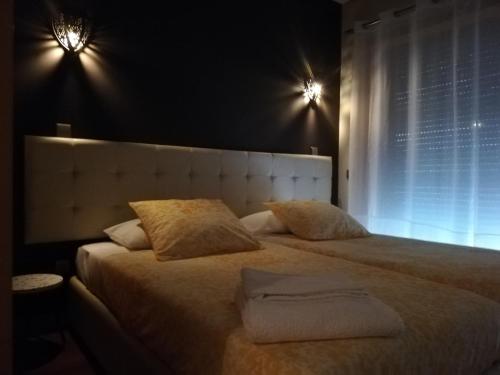 a bedroom with a large bed with two pillows at André´s São João Porto Apt. in São Mamede de Infesta