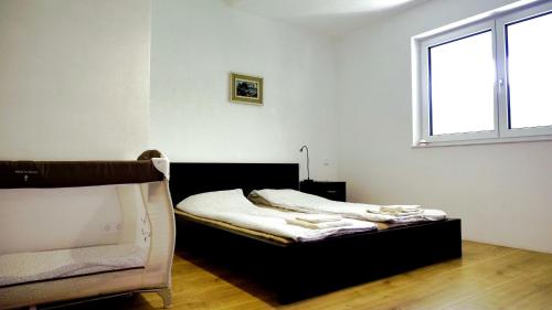 a bedroom with a bed and a window at Flamind Holiday Apartments mit Garten und Grill in Altenberg bei Linz
