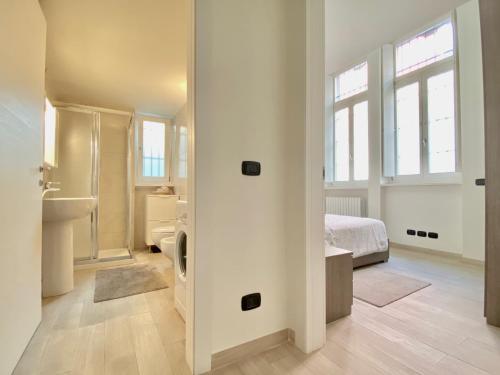 a white bedroom with a bed and a bathroom at Future Apartments in Milan