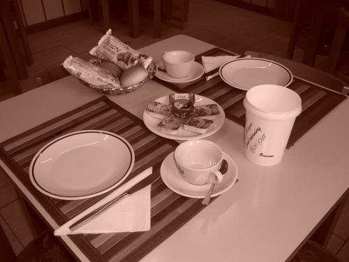 una mesa con platos de comida y una taza de café en Hotel Milano, en Como