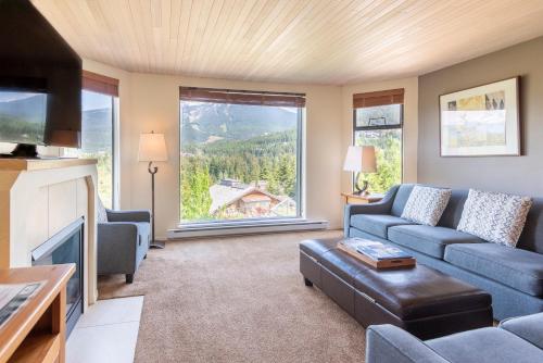 a living room with a couch and a large window at The Ironwood on Blueberry Hill in Whistler