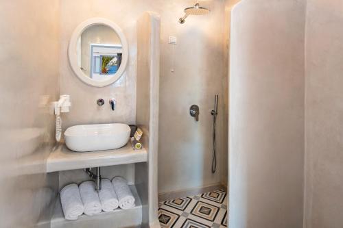 bagno con lavandino e specchio di Akrotiri Hotel ad Akrotírion