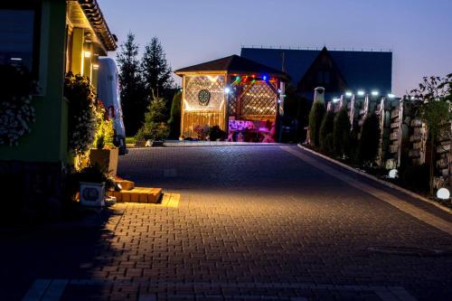 a house decorated with christmas lights in a driveway at Agroturystyka Piekielnik in Piekielnik
