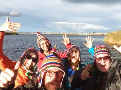 a group of people in hats standing in front of the water at Luz del Titicaca Lodge in Puno