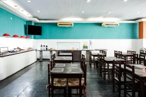 a restaurant with tables and chairs and a blue wall at Hotel InterAmericana in Americana