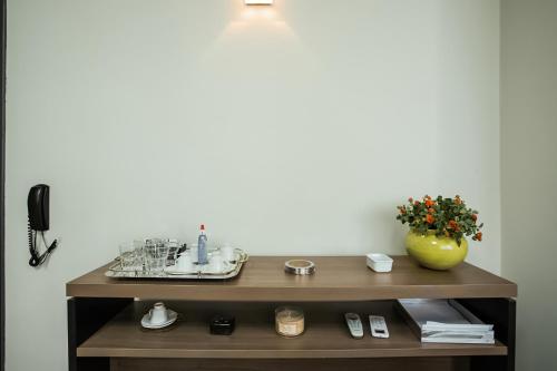 een badkamerplank met een wastafel en een vaas met bloemen bij Hotel InterAmericana in Americana
