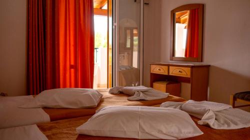 two beds in a room with a mirror at Tria Adelphia in Arillas