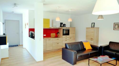 a living room with a couch and a kitchen at Flamind Holiday Apartments in Altenberg bei Linz