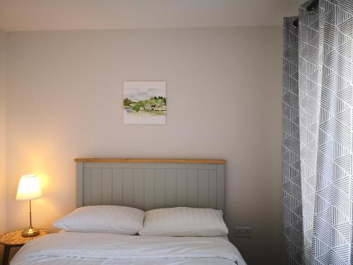 a bed with two pillows and a picture on the wall at Reading New Luxury House Wz Garden&Parking by L&S in Reading