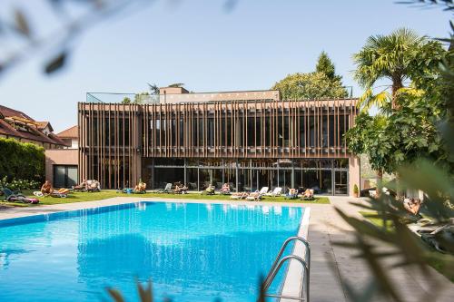 einem großen Pool vor einem Gebäude in der Unterkunft Hotel CampingPark Steiner in Leifers