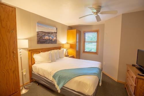 1 dormitorio con 1 cama y ventilador de techo en Westwood Shores Waterfront Resort, en Sturgeon Bay