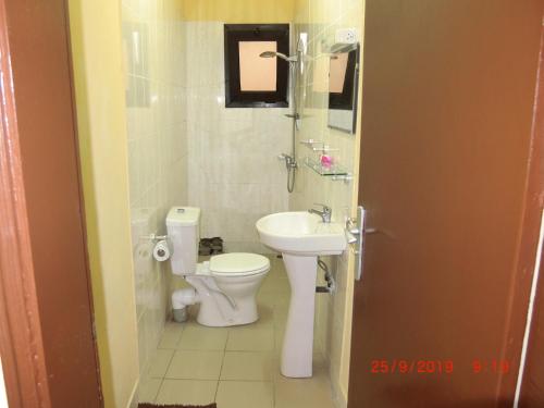 La salle de bains est pourvue de toilettes et d'un lavabo. dans l'établissement Dreams House, à Libreville