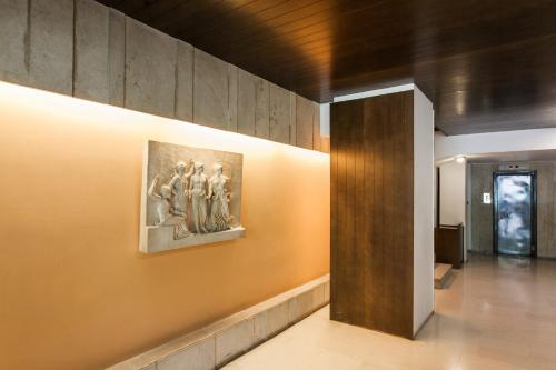 a wall with a painting of three people on it at Homz Studios Faliro in Athens