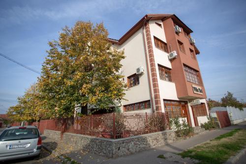 a building with a car parked in front of it at Vila Tei GuestHouse in Târgu Jiu