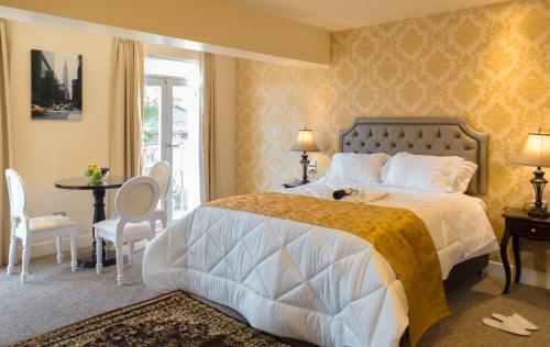 a bedroom with a bed and a table and chairs at Hotel Paradis Suite Cusco in Cusco