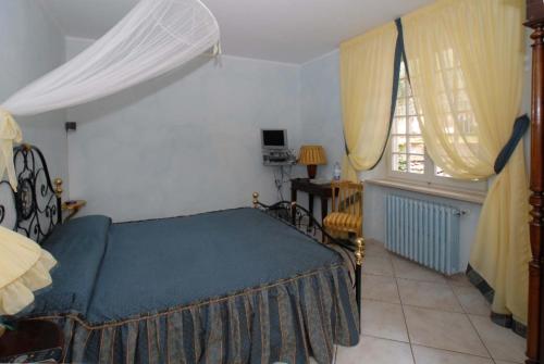 a bedroom with a bed and a table and a window at Maison Brinati Bed and Breakfast in Monsummano Terme