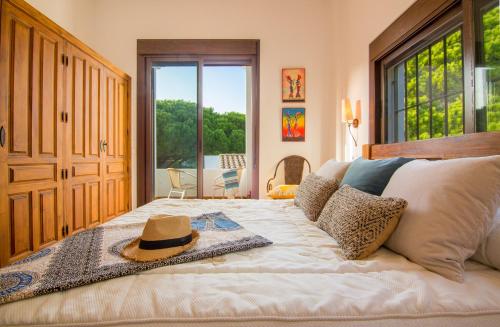 a bedroom with a bed with a hat on it at Casas Los 4 Soles in Los Caños de Meca