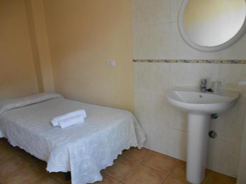 a bathroom with a sink and a white bed and a mirror at Pensión Mova in Santa Cruz de Tenerife