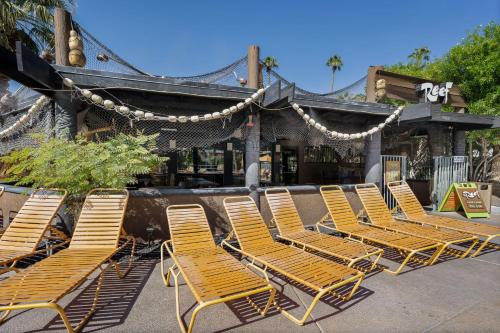 a group of chairs sitting in front of a building at Caliente Tropics in Palm Springs