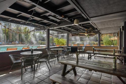 a restaurant with tables and chairs and a pool at Caliente Tropics in Palm Springs