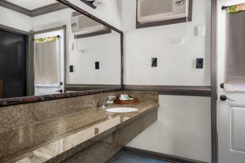 a bathroom with a sink and a mirror at Caliente Tropics in Palm Springs