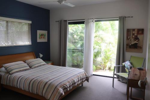 a bedroom with a bed and a large window at @LIZZIE in Elizabeth Beach