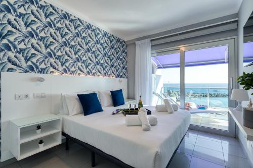 ein Schlafzimmer mit einem großen Bett mit einer blauen und weißen Tapete in der Unterkunft Teresita Mogamar Beachfront in Puerto de Mogán