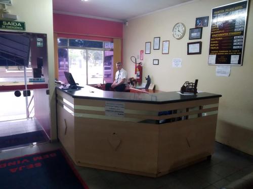 a man sitting at a counter in a fast food restaurant at FRONTIER PALACE HOTEL in Ponta Porã