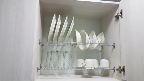 a shelf with white plates and vases on it at ELEGANTE, CÓMODO Y MODERNO APARTAMENTO - SUR DE CALI in Cali