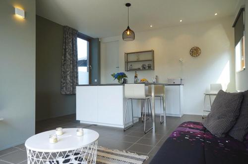 a living room with a kitchen and a table at La Cassine de Patou in Stoumont
