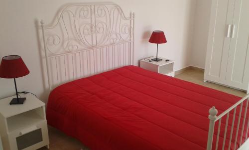 a bedroom with a large red bed with two lamps at Casa Almeida in Vimieiro