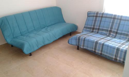 a blue couch and a chair in a room at Casa Almeida in Vimieiro