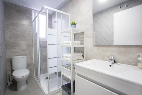 y baño con aseo, lavabo y espejo. en Apartamento en primera línea en Puerto de Sagunto en Puerto de Sagunto