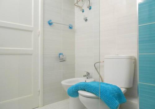 baño con aseo y manta azul en Endless Blue Apartment, en Costa Teguise