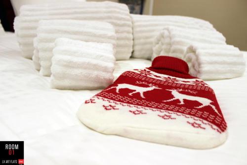 a red and white hat on a bed with towels at Lx Art Flats | Flat Two in Lisbon