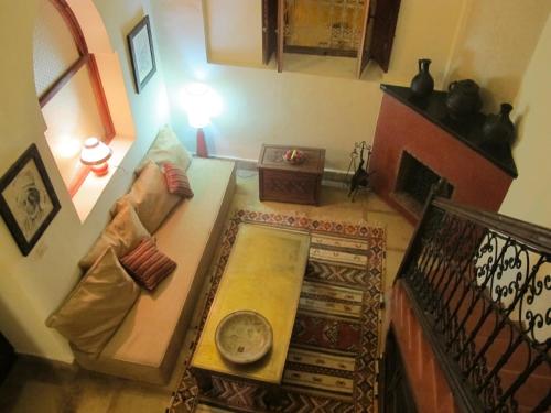 a living room with a couch and a fireplace at Riad Al Loune in Marrakech