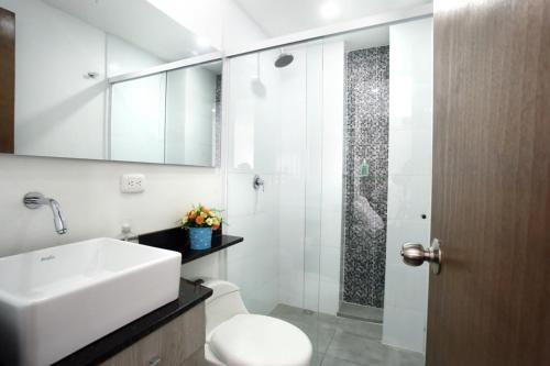 a bathroom with a sink and a toilet and a mirror at New Studio Apartment for Two in Medellín