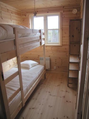 a bedroom with two bunk beds in a log cabin at Linnaeus - 6 person cabin in Al