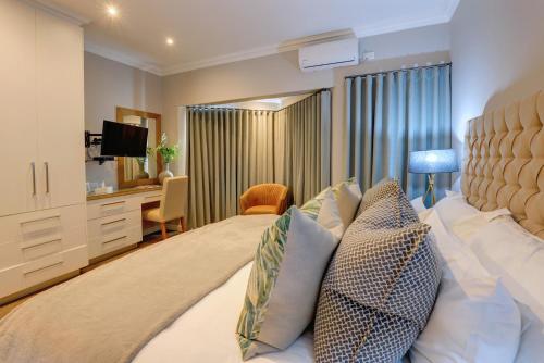 a bedroom with a large bed and a desk at Bay Lodge on the Beach in Mossel Bay