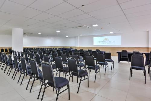 a room with rows of chairs and a screen at Nobile Inn London Anápolis in Anápolis