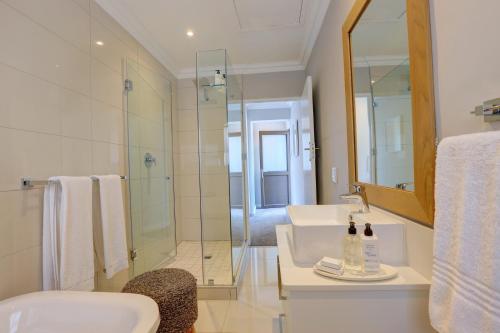 a bathroom with a sink and a shower at Bay Lodge on the Beach in Mossel Bay