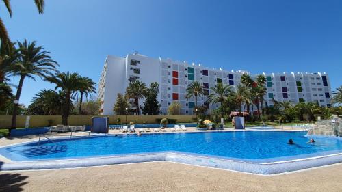 a large swimming pool in front of a large building at Atlantic Coast Apartment - Playa Del Inglés in Playa del Ingles