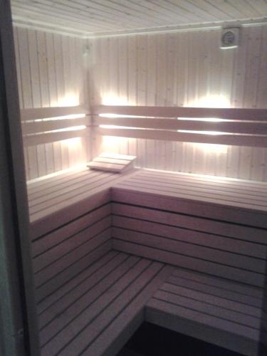 a sauna with white walls and lights in it at Hotel Skarpa in Sejny