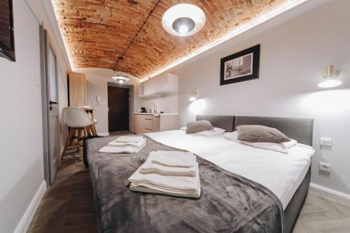 sypialnia z dużym łóżkiem z ręcznikami w obiekcie Platan Apartments-5 min Main sqr-large bed-unique w Krakowie