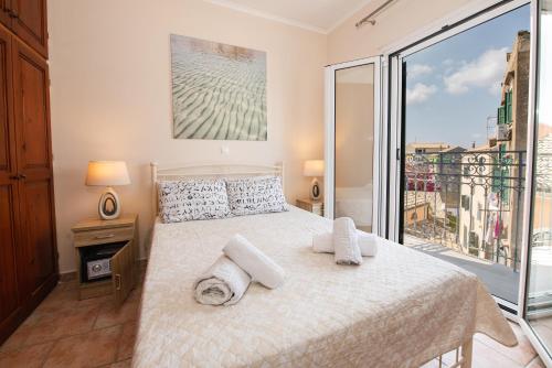 a bedroom with a bed and a large window at City walls sea view in Corfu Town