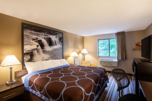 a hotel room with a bed and a window at Super 8 by Wyndham Elkins in Elkins
