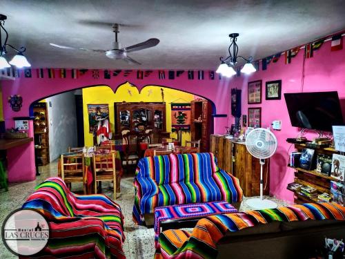 una habitación con 2 sillas y una habitación con paredes rosas en Hostal Las Cruces, en Valladolid