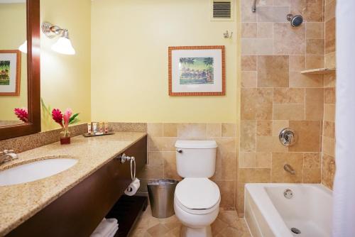 a bathroom with a toilet and a sink and a tub at Kauai Beach Resort & Spa in Lihue