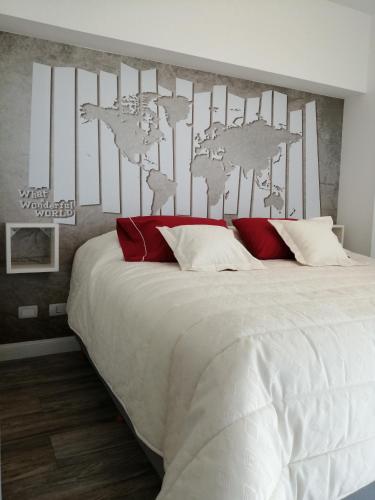 a bedroom with a large white bed with red pillows at star apartment olivos in Olivos