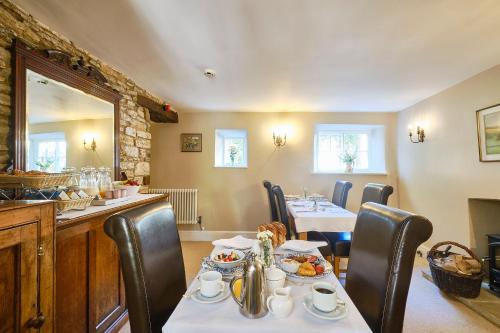 a dining room with two tables and chairs with food at Nuns Cottage Bed & Breakfast in Richmond
